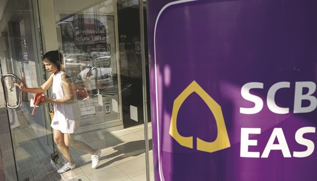 A woman walks out of a Siam Commercial Bank branch in Bangkok. The Thai lender is seeking a partner for its insurance unit to accelerate growth in the business.