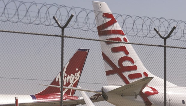 Virgin planes are parked next to each other at Kingsford Smith airport in Sydney. The owner of Hainan Airlines will buy 13% of Virgin Australia for A$159mn ($114mn) and plans to raise that stake to about 20% over time, the Australian carrier said yesterday.
