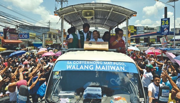 Presidential candidate Senator Grace Poe (centre, aboard a truck) greets supporters during a campaign sortie in General Mariano Alvares town in Cavite province, southwest of Manila yesterday.