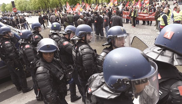 French riot police stand in front of protesters during a demonstration yesterday against the governmentu2019s planned labour law reforms.