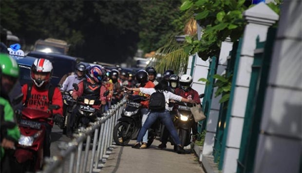 Alfini Lestari daringly blocks a group of motorcyclists in Jakarta. Picture: The Jakarta Post