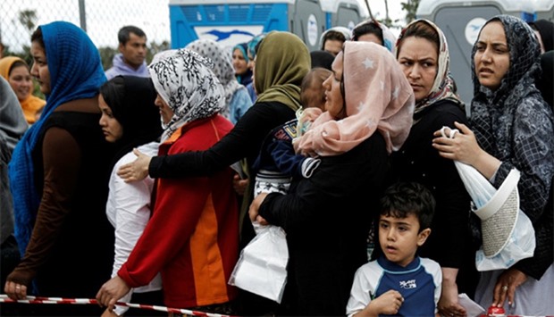 Migrants line up to receive  goods