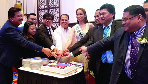 CAKE-CUTTING: Philippine ambassador Wilfredo Santos, fifth left, led the ceremonial cutting of cake to mark the month-long Independence Day celebration on Tuesday. He was joined by Mutya ng Pilipinas-Tourism Janela Joy Cuaton and Independence Day Committee members. Photo by Joey Aguilar
