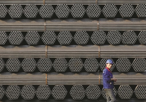 A worker walks past a pile of steel pipe products at a plant in Tangshan, Hebei province. Beijing is pressing Obamau2019s administration to treat China like a u2018market economy,u2019 a move that would spell lower tariffs on controversial Chinese exports like steel.