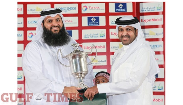 Sheikh Abdulrahman bin Mubarak al-Thani (right) presents the owneru2019s trophy to Mishal bin Ali al-Attiyah after Al Hareth won The Late Sheikh Mubarak bin Abdulrahman al-Thani Cup yesterday. PICTURES: Juhaim