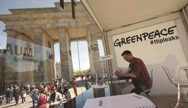 This picture taken on Monday shows a man reading a copy of the leaked TTIP negotiations inside a public reading room set up by Greenpeace in front of the Brandenburg Gate in Berlin.