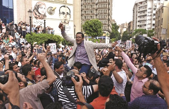 Khaled Elbalshy (centre), board member of Egyptu2019s Press Syndicate and the head of its Freedomsu2019 Committee, demonstrates with journalists outside the Journalist Syndicate headquarters in Cairo calling for the sacking of the interior minister following an unprecedented police raid to arrest two reporters yesterday.