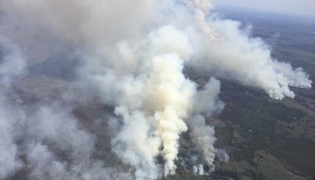 An aerial view shows smoke rising from raging wildfires which caused the mandatory evacuation of Fort McMurray in Alberta, Canada.