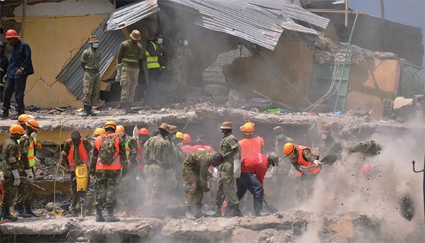 Rescue and medical personnel try to free a woman (unseen) who discovered alive in Nairobi after being trapped for six-days 