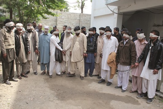 Members of a tribal council accused of ordering the burning death of a 16-year-old girl are shown to the media after they were arrested by police in Donga Gali, outside Abbottabad, Pakistan, yesterday.