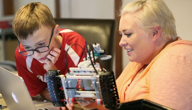 Grayson Zrelak builds a robot with Megan Nickels.
