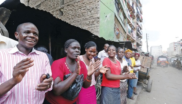 Residents cheer as Kenya Red Cross rescuers evacuate the woman from the rubble.