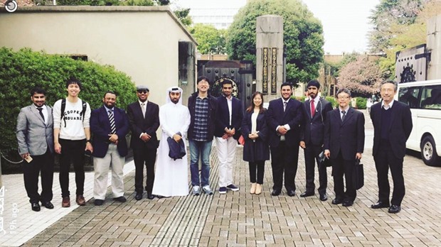 QU students with officials in Japan.