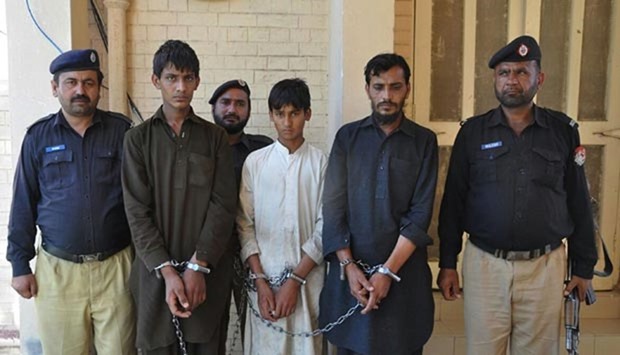 Pakistani policemen escort Tariq Mehmood (second right), his younger brother Khalid Mehmood (second left) and an employee at a court in the Karor Lal Esan area of Pakistan's Punjab province.