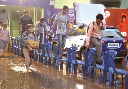 People make their way through Kanteerva stadium after heavy rains lashed Bengaluru, Karnataka, yesterday. Heavy showers accompanied by squalls also lashed Telangana and Andhra Pradesh, officials said.