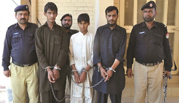 Policemen escort Tariq Mehmood, second right, his younger brother Khalid Mehmood, second left, and an employee at a court in the Karor Lal Esan area of Punjab province yesterday.