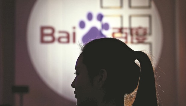 A woman is silhouetted against the Baidu logo in Shanghai. The death of a student following experimental cancer treatment he found through Chinau2019s biggest search engine has exposed the faultlines in the firmu2019s business model.