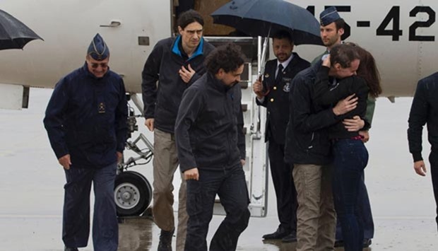 Spanish freelance journalists Angel Sastre (third left), Jose Manuel Lopez (second left) and Antonio Pampliega (right) arrive at Torrejon military airport in Madrid on Sunday.