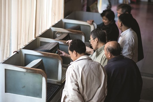 Investors follow financial information at a securities brokerage in Shanghai. The Shanghai Composite Index has rebounded from its January 28 low as economic data and the nationu2019s currency stabilised.