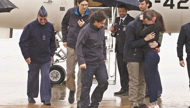 A handout photo released by Presidencia del Gobierno shows journalists Sastre (third left), Lopez (second left) and Pampliega (hugging his sister Alejandra) arriving at Torrejon military airport in Madrid.