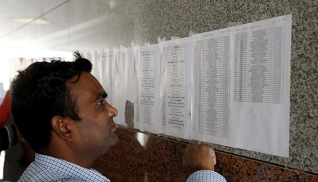 A Saudi Binladin Group migrant worker looks for his name on a salary list in Riyadh in March this year.