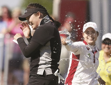 Ariya Jutanugarn of Thailand celebrates with her sister, Moriya, on the 18th hole after winning the Yokohama Classic in Prattville, Alabama, on Sunday. (AFP)