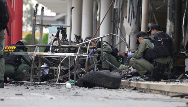 Thai Army investigators take a close look at the site of where a bomb was detonated in the southern city of Pattani, in southern Thailand