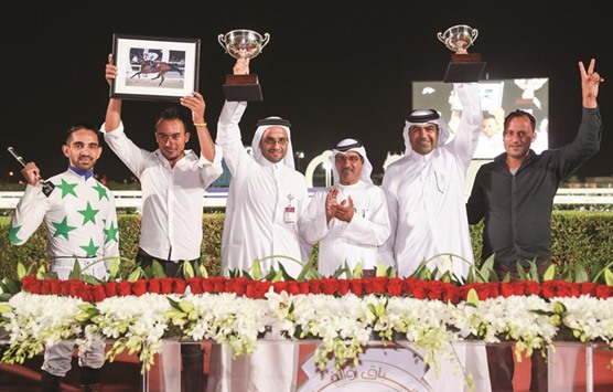 Qatar Racing and Equestrian Club (QREC) vice chief steward Abdulla Rashid al-Kubaisi with the winners of Muaither Cup after Topsy Turvy won the 1,900m race at the QRECu2019s dirt track yesterday. PICTURE: Juhaim