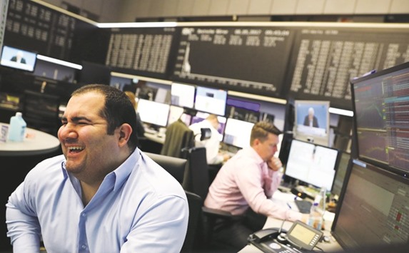 Traders work at the Frankfurt Stock Exchange. The DAX 30 closed up 0.1% to 12,757.46 points yesterday.