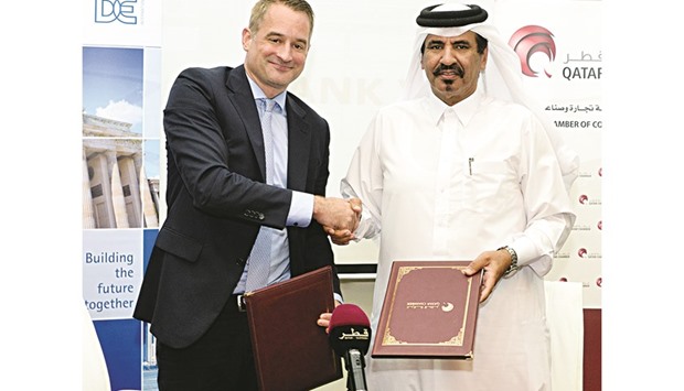 Al-Kuwari and Neugart shake hands after signing an agreement following yesterdayu2019s meeting at the Qatar Chamber headquarters.