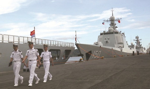 Chinese Navy officers walk past a Chinese naval ship on a visit to Davao city, southern Philippines, yesterday.