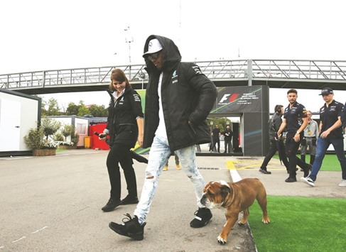 Mercedesu2019 Lewis Hamilton walks with his dog by the paddock yesterday. (Reuters)