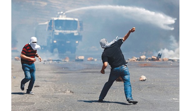Palestinian protesters throws stones towards Israeli security forces during clashes near the Jewish settlement of Beit El, north of the West Bank city of Ramallah.