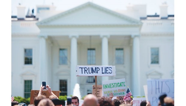 A protester holds a placard in front of the White House during a protest demanding an independent investigation in the Trump/Russia ties after the firing of FBI Director James Comey in Washington, DC.