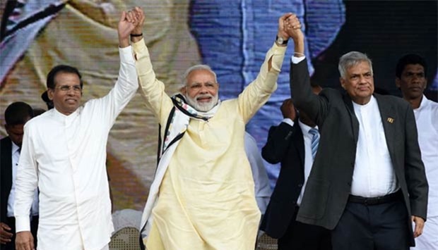 Indian Prime Minister Narendra Modi joins hands with Sri Lankan President Maithripala Sirisena and Prime Minister Ranil Wickremesinghe after addressing a public rally near Colombo on Friday.