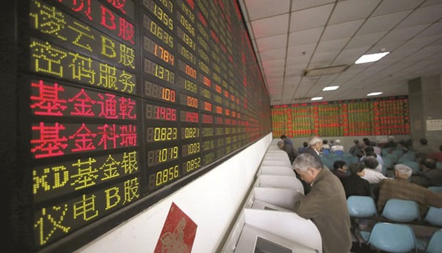 Investors look at computer screens showing stock information at a brokerage house in Shanghai. The Shanghai Composite Index, notorious for its wild swings over the past two years, has gone 85 trading days without a loss of more than 1% on a closing basis, the longest stretch since the marketu2019s infancy in 1992.