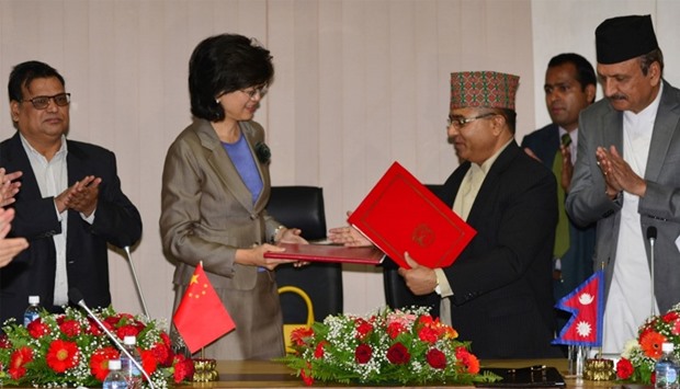Nepal's Foreign Secretary Shankar Das Bairagi and China's Ambassador to Nepal Yu Hong (2nd L) exchange documents during a signing ceremony