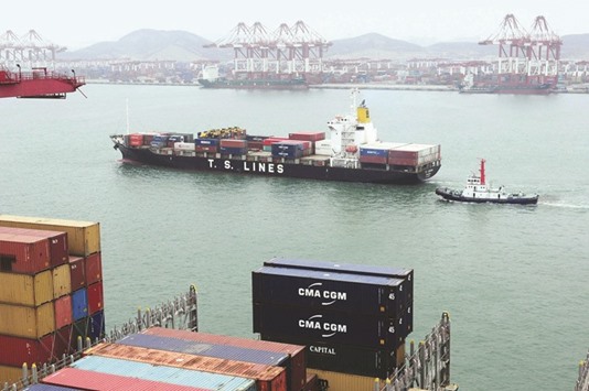 Shipping containers are transported in a port in Qingdao, east Chinau2019s Shandong province (file). China stands to gain not just by putting to work its underused industrial capacity and excess production of steel and other materials, but also by pushing its goal of deepening the global reach of its currency.