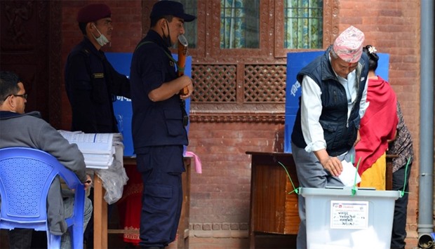 A man drops his vote into a ballot box at a polling station in Thimi, on the outskirts of Kathmandu