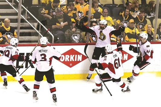 Ottawa Senators players celebrate after scoring.