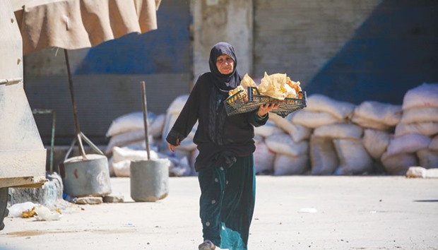 A Syrian woman walks down a street in the town of Tabqa.