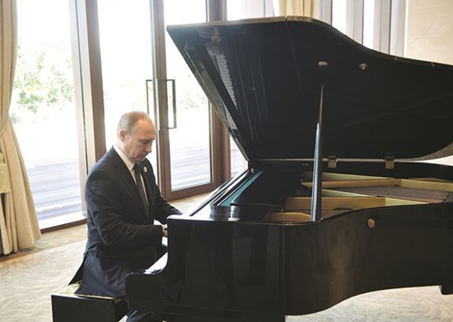 Putin plays the piano before meeting Xi.