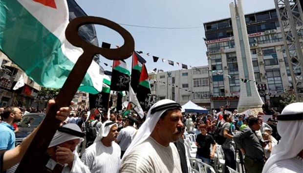 A Palestinian man holds a symbolic key during a rally marking the 69th anniversary of Nakba, in the West Bank city of Ramallah on Monday.