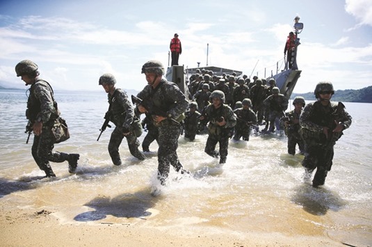 Filipino soldiers disembark from the landing ship before they dock at Motiong Beach, as part of the Humanitarian Assistance and Disaster Response scenario during the annual Balikatan  (Shoulder-to-Shoulder) exercises in Casiguran, yesterday.
