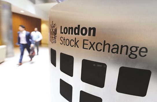 Visitors pass a sign inside the main atrium of the London Stock Exchange Group (LSE) headquarters. The FTSE 100 ended the day at a record closing level of 7,454.37 points.