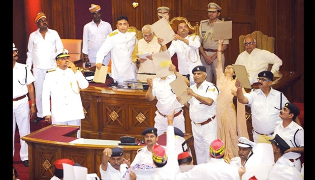 Uttar Pradesh Governor Ram Naik is shielded by security personnel from paper missiles being hurled by opposition members in the Uttar Pradesh Assembly yesterday.