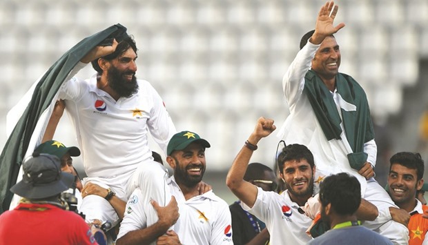 Retiring members of the Pakistan cricket team, Misbah-ul-Haq (left) and Younis Khan (right), are carried by their teammates as they celebrate winning the three-Test series against the West Indies 2-1 in Roseau, Dominica, on Sunday. (AFP)