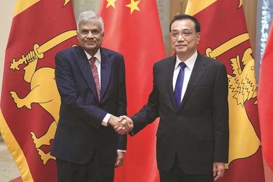 Ranil Wickremesinghe, left, shakes hands with Chinese Premier Li Keqiang at the Great Hall of the People in Beijing yesterday.