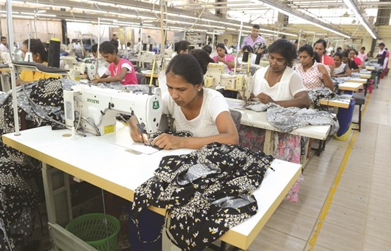 Workers make clothes at a garment factory in Colombo yesterday.