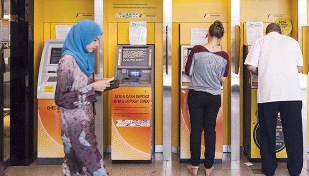 Customers use ATMs at a combined Malayan Banking Bhd (Maybank) and Maybank Islamic Bhd bank branch in Kuala Lumpur. The market shares of Islamic banks increased in 18 jurisdictions, indicating a growing acceptance of Islamic finance in markets with both Islamic and conventional financial systems, according to the IFSI Stability Report 2017.